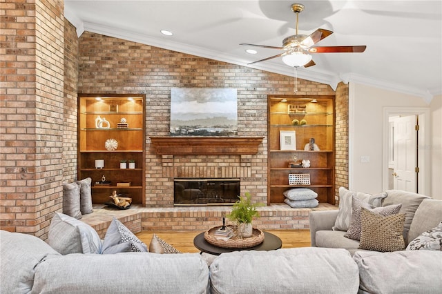 living room featuring ceiling fan, a fireplace, wood-type flooring, and vaulted ceiling