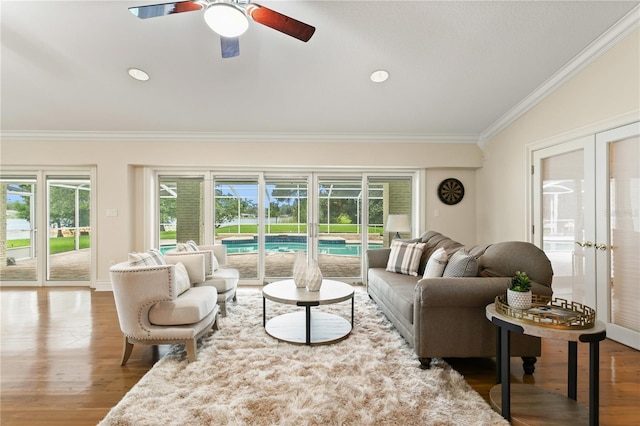 living room featuring ceiling fan, french doors, hardwood / wood-style floors, lofted ceiling, and ornamental molding