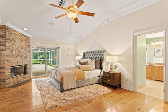 bedroom with access to exterior, light wood-type flooring, ceiling fan, a fireplace, and connected bathroom