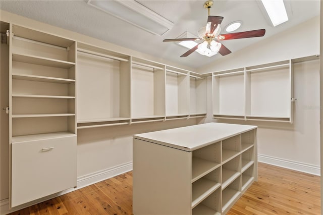 walk in closet with light hardwood / wood-style floors, ceiling fan, and lofted ceiling