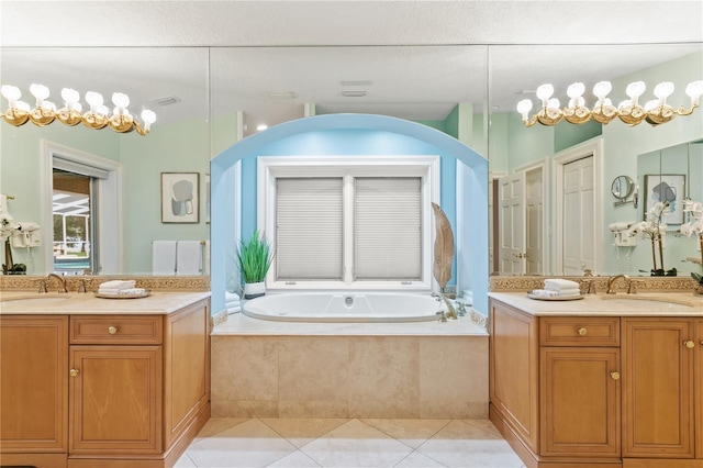 bathroom featuring tile patterned floors, vanity, and a relaxing tiled tub