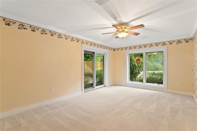 carpeted empty room with ceiling fan, a textured ceiling, and ornamental molding