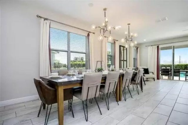 dining area featuring light tile patterned flooring and an inviting chandelier