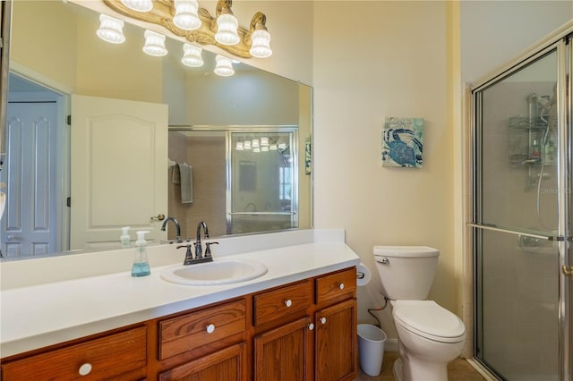 bathroom with vanity, a shower with door, and toilet