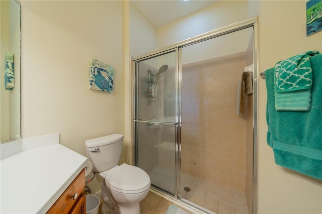 bathroom featuring vanity, tile patterned flooring, a shower with door, and toilet