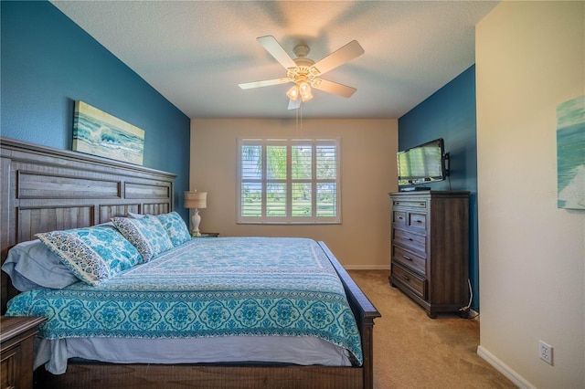 carpeted bedroom with ceiling fan and a textured ceiling