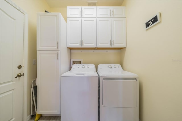 washroom featuring washer and clothes dryer and cabinets