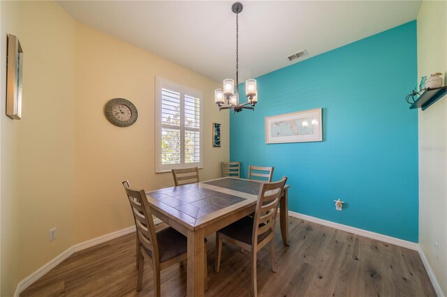 dining area featuring hardwood / wood-style flooring and a chandelier