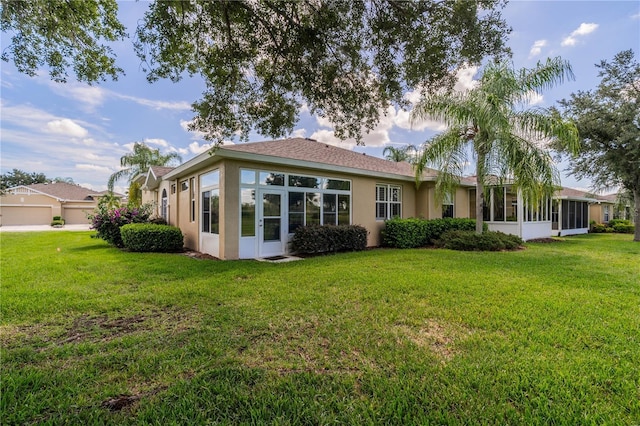 back of house featuring a yard and a sunroom