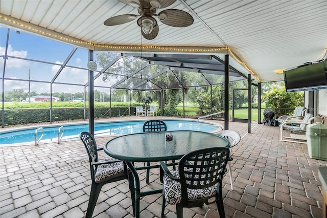 view of swimming pool with a patio area, ceiling fan, and a lanai