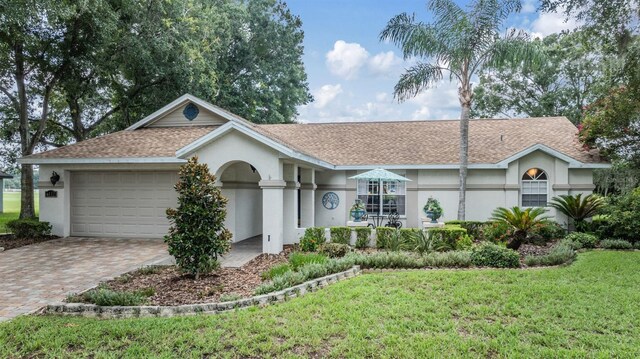 ranch-style home with a garage and a front lawn