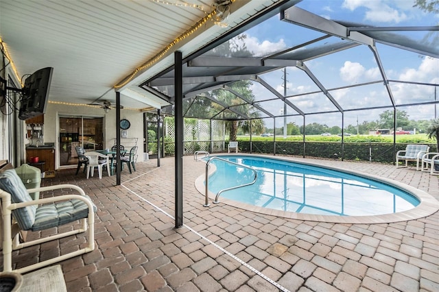 view of swimming pool with glass enclosure and a patio