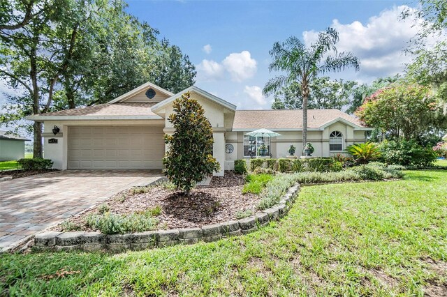 single story home featuring a garage and a front lawn