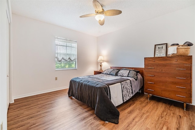 bedroom featuring a textured ceiling, ceiling fan, and hardwood / wood-style flooring