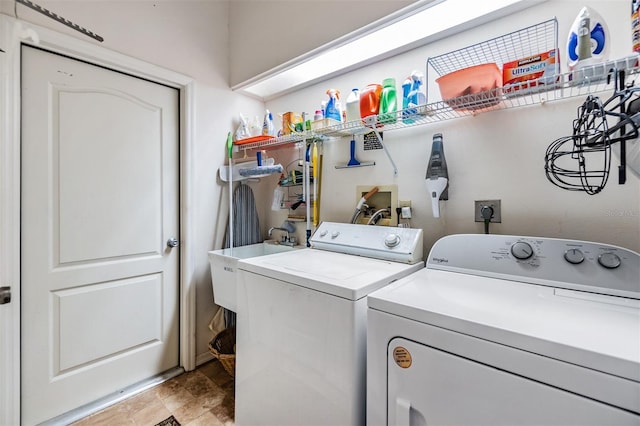 clothes washing area featuring washing machine and dryer and sink