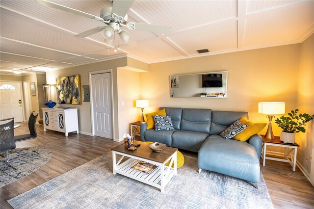 living room with hardwood / wood-style flooring, ceiling fan, and crown molding