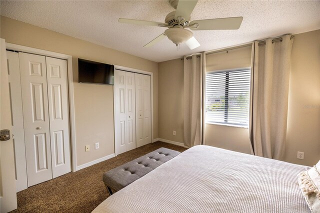 bedroom featuring a textured ceiling, two closets, ceiling fan, and carpet floors