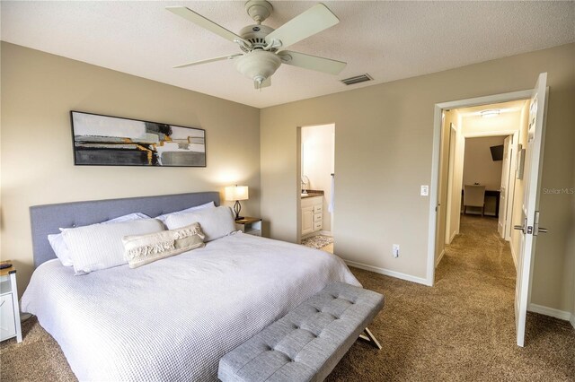 carpeted bedroom featuring a textured ceiling, ensuite bathroom, and ceiling fan