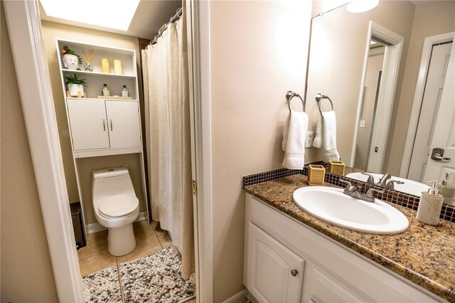 bathroom featuring tile patterned flooring, vanity, and toilet