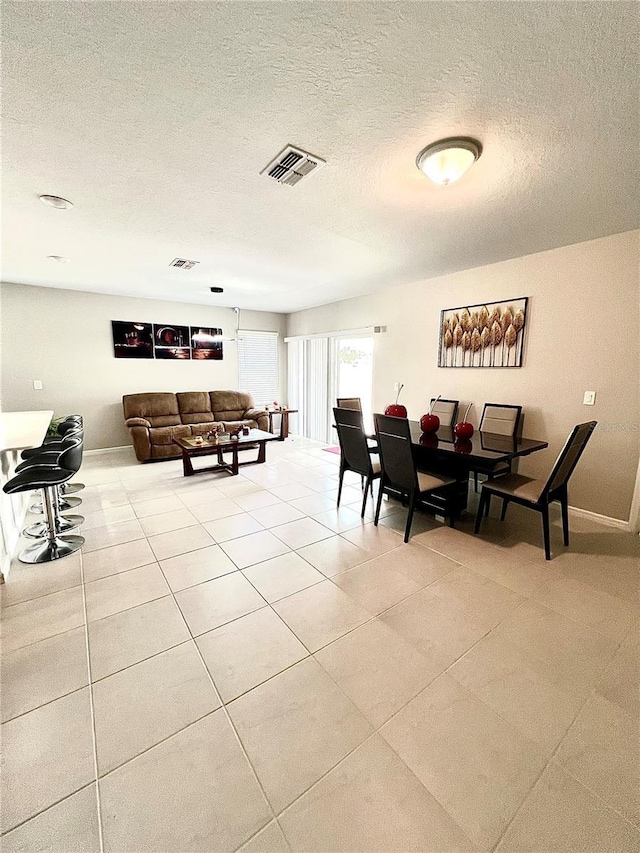 tiled dining room with a textured ceiling