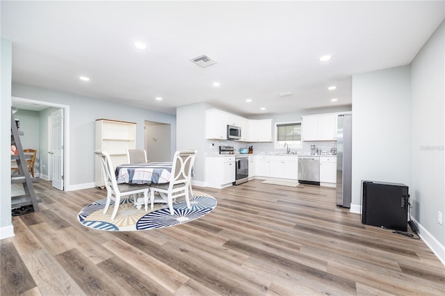 dining area featuring sink and light hardwood / wood-style floors