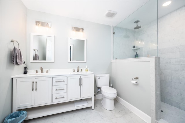 bathroom with vanity, a tile shower, and toilet