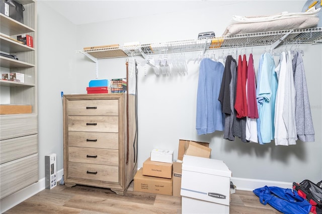 walk in closet with light hardwood / wood-style floors