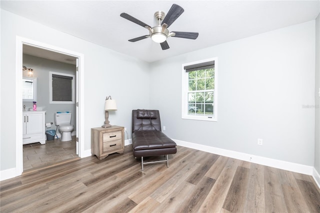 living area with wood-type flooring and ceiling fan