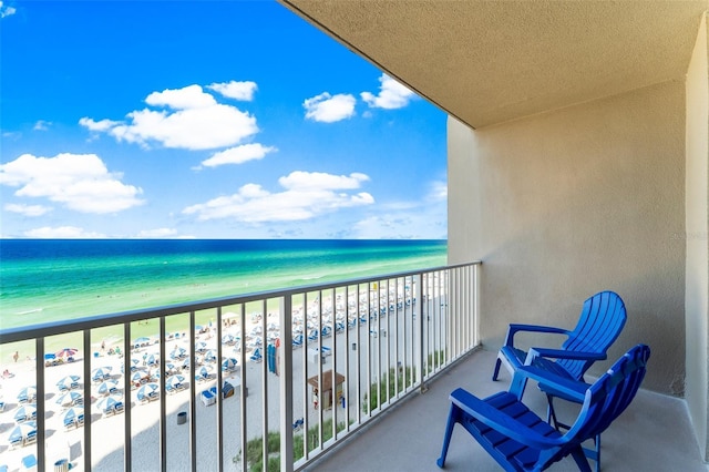 balcony featuring a water view and a beach view