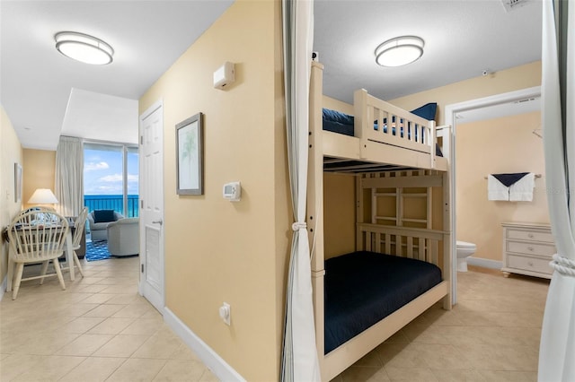 bedroom with a water view and light tile patterned floors