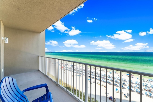 balcony featuring a water view and a beach view