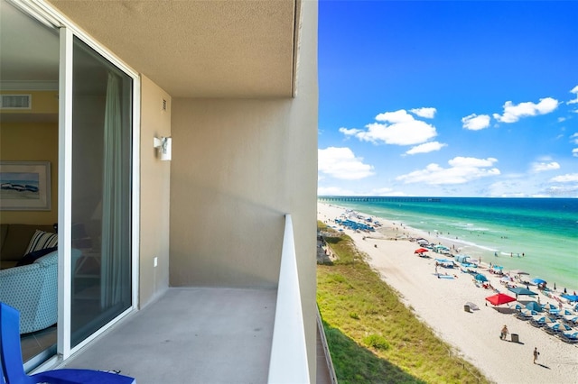 balcony with a water view and a beach view