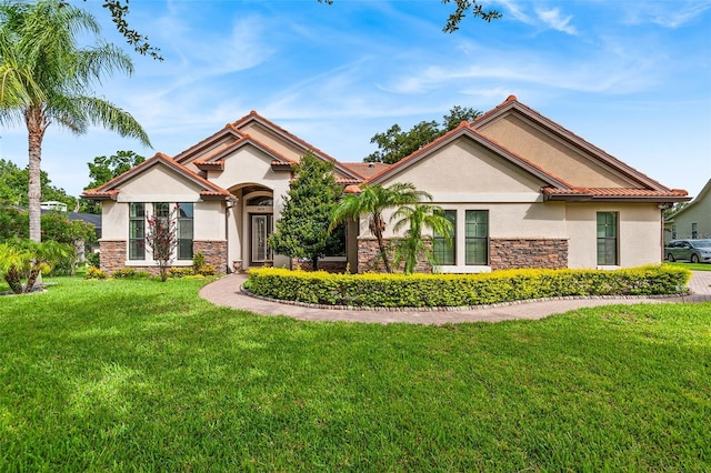 mediterranean / spanish home featuring a front lawn