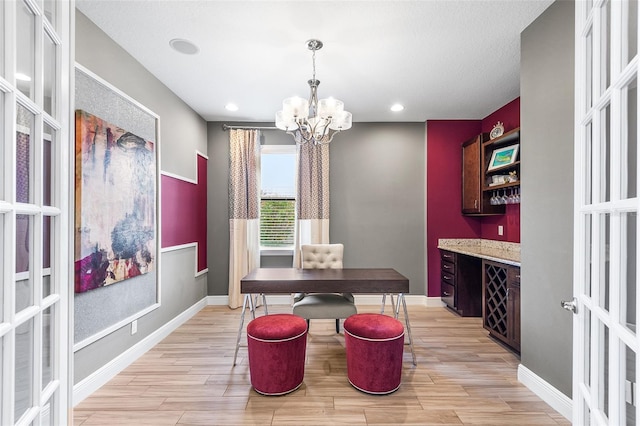 dining space with french doors and an inviting chandelier