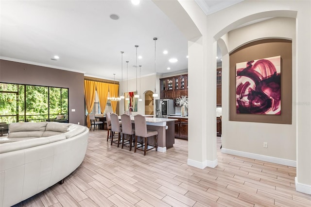 living room with light wood-type flooring and ornamental molding