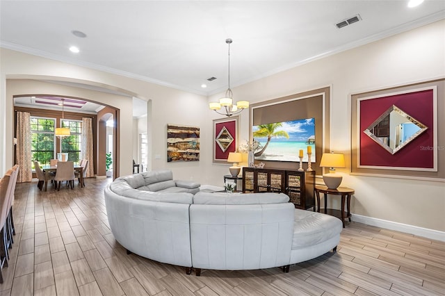 living room featuring crown molding and a notable chandelier