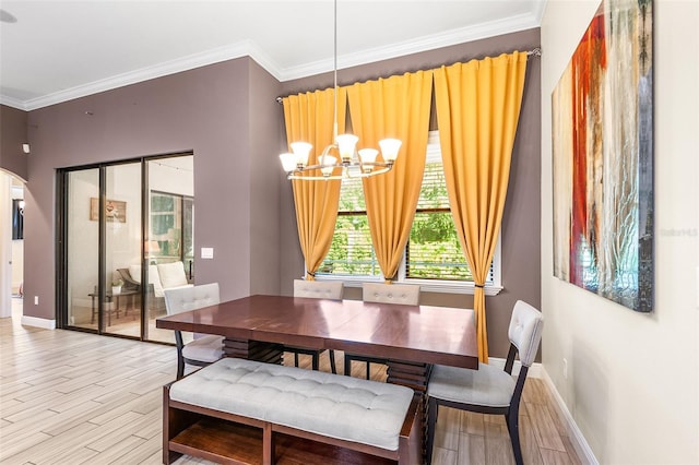 dining space featuring light hardwood / wood-style flooring, ornamental molding, and a notable chandelier