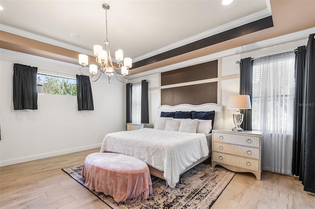 bedroom with a chandelier, light wood-type flooring, a raised ceiling, and crown molding