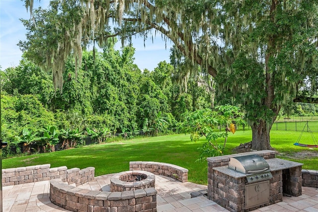 view of patio featuring an outdoor kitchen, area for grilling, and an outdoor fire pit