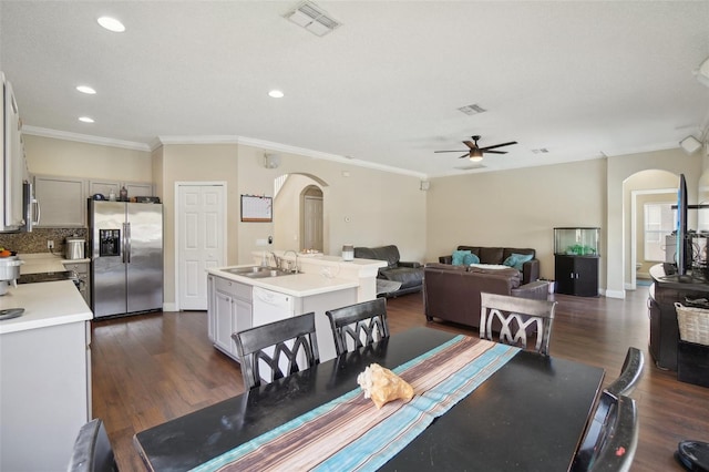 dining space with ceiling fan, dark hardwood / wood-style floors, sink, and ornamental molding