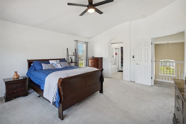 bedroom with vaulted ceiling, ceiling fan, ensuite bathroom, and light carpet