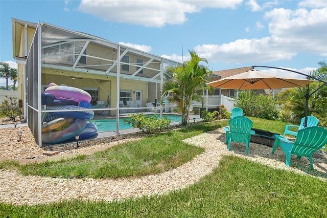 view of pool with a lawn, a patio area, and glass enclosure