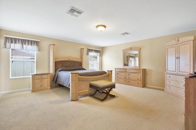 bedroom with light carpet and a textured ceiling