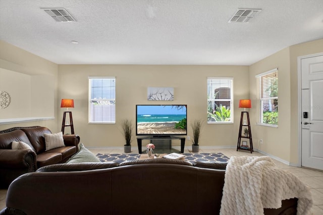 living room featuring a textured ceiling and light tile patterned floors