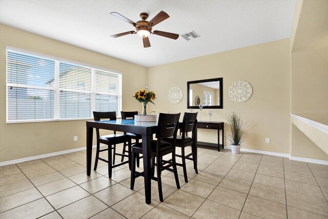 tiled dining space with ceiling fan