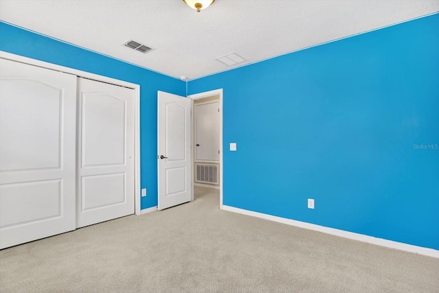 unfurnished bedroom featuring a closet and light colored carpet