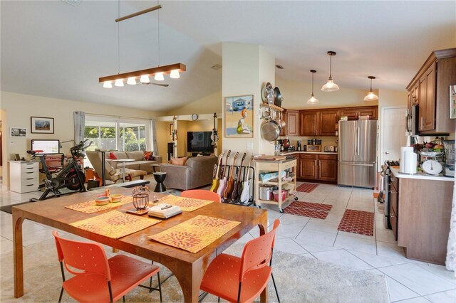 dining space with lofted ceiling and light tile patterned flooring