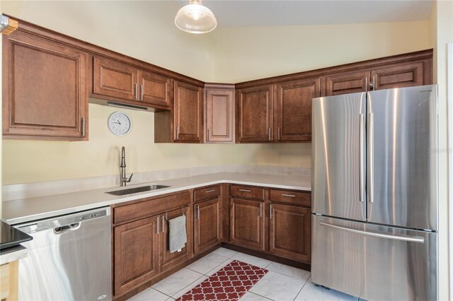 kitchen with sink, hanging light fixtures, stainless steel appliances, vaulted ceiling, and light tile patterned flooring