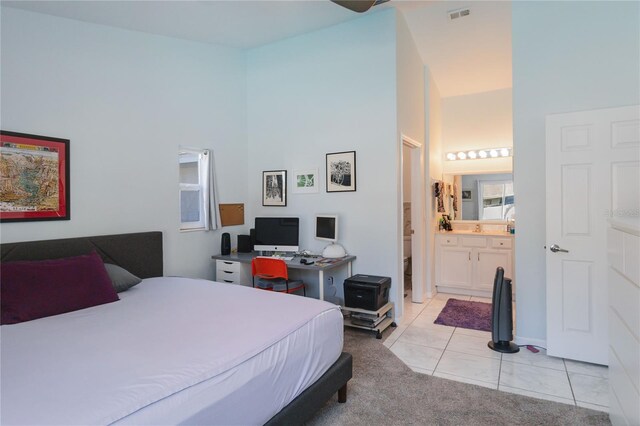 bedroom featuring connected bathroom and light tile patterned floors