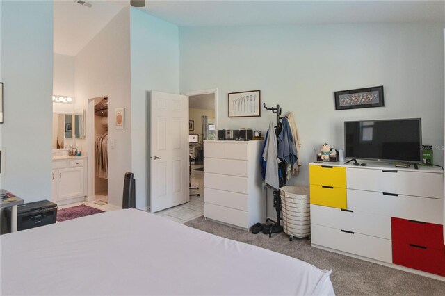 bedroom featuring light carpet and connected bathroom